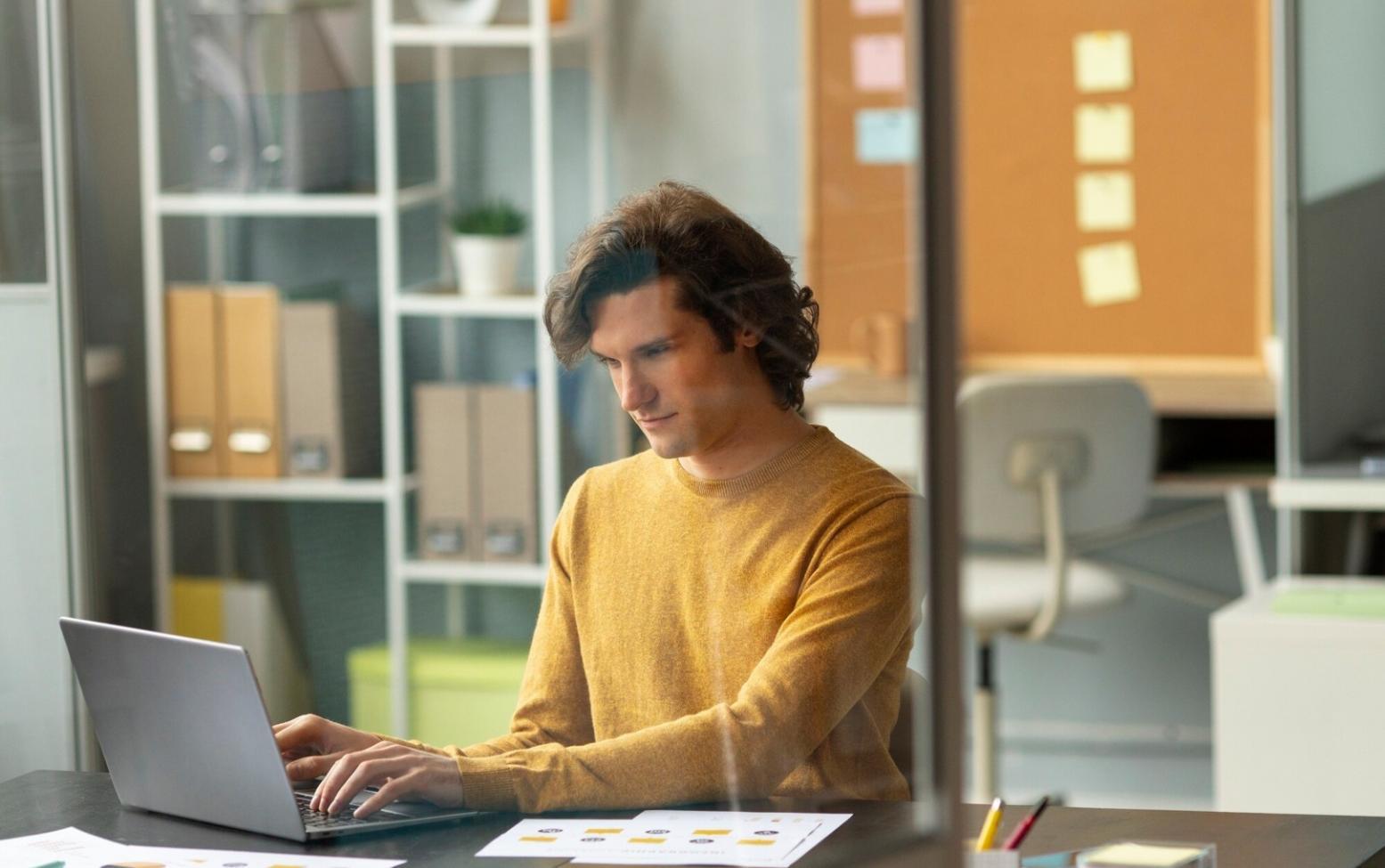 Team meeting discussing investment strategies with research documents and laptops